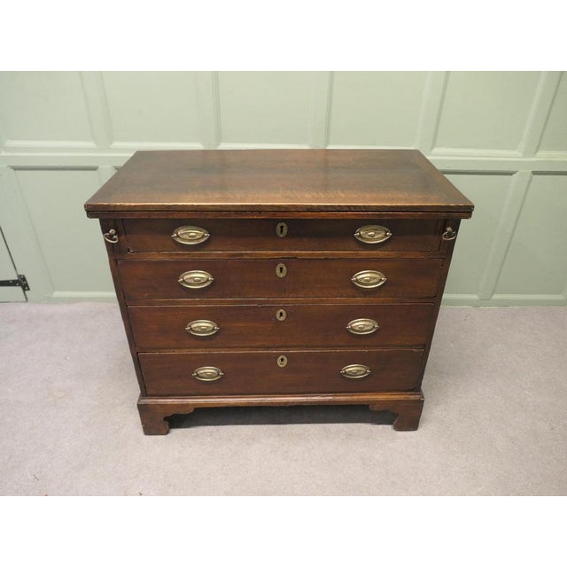 This Attractive Bachelor’s Chest has four long graduated drawers and the additional advantage of a fold over top to make a...