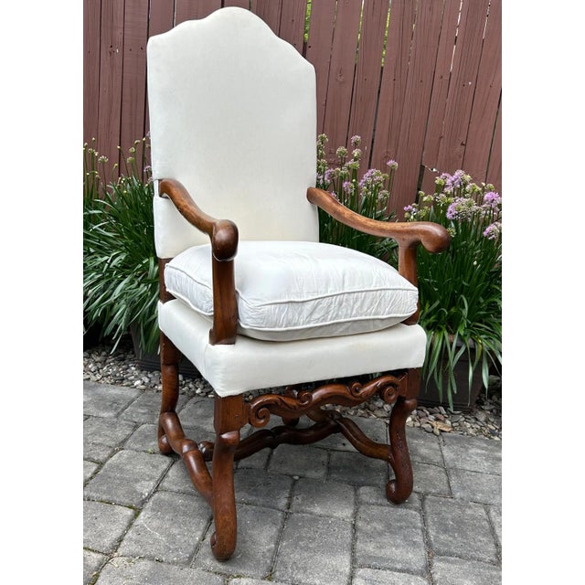 Louis XIV Walnut Mutton Bone Armchair, early 18th century, having an arched crestrail, upholstered back, loose seat...