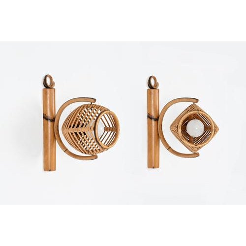 Magnificent pair of midcentury adjustable wall lamps fully made in curved rattan and hand-woven wicker. These fantastic...