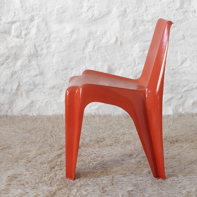 Orange fiberglass-reinforced polyester resin chair. It is the first plastic chair in history manufactured in a single...