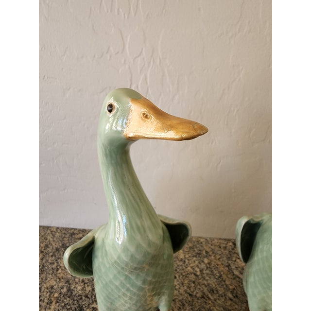 A charming pair of vintage Chinese celadon glazed ducks, modeled as mirror images so they face each other when displayed....