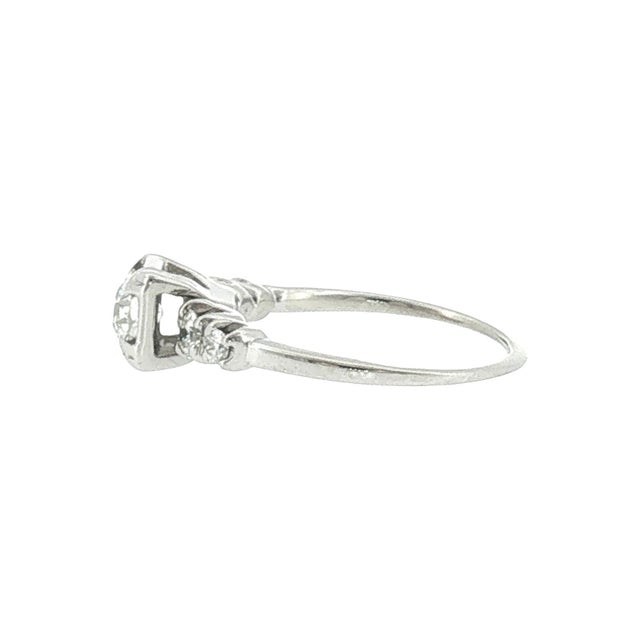 A mid-century 14k gold engagement ring featuring 5 diamonds. The center stone is an approximately 0.5-carat Old European...
