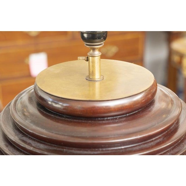 This is a handsome pair of table lamps crafted from richly figured mahogany, each featuring a bold spherical body carved...
