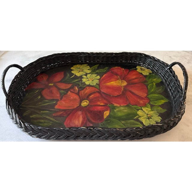Vintage black wicker oval serving tray with two side handles and featuring a beautiful hand painted floral design on the...