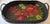 Vintage black wicker oval serving tray with two side handles and featuring a beautiful hand painted floral design on the...