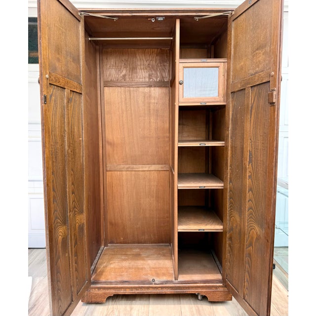 Dating to the early-to-mid 20th century, this handsome English oak wardrobe by Crown AY Furniture showcases the rich...