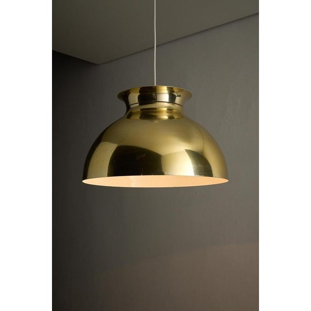 Substantial pendant light from the 1970s, features a classic mid-century dome silhouette. The shade is crafted from spun...