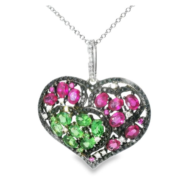 Exquisite 18K white & black gold heart pendant featuring red and green sapphires with sparkling black and white diamonds....