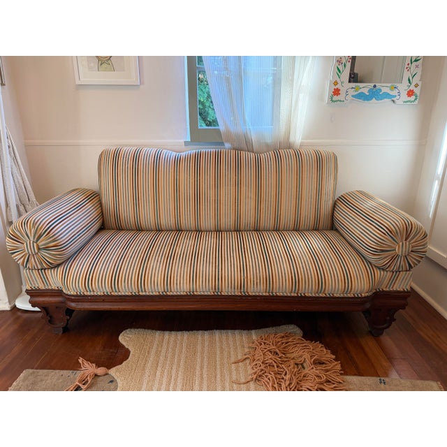 Antique Victorian carved walnut settee, professionally reupholstered in contemporary striped velvet with matching bolster...