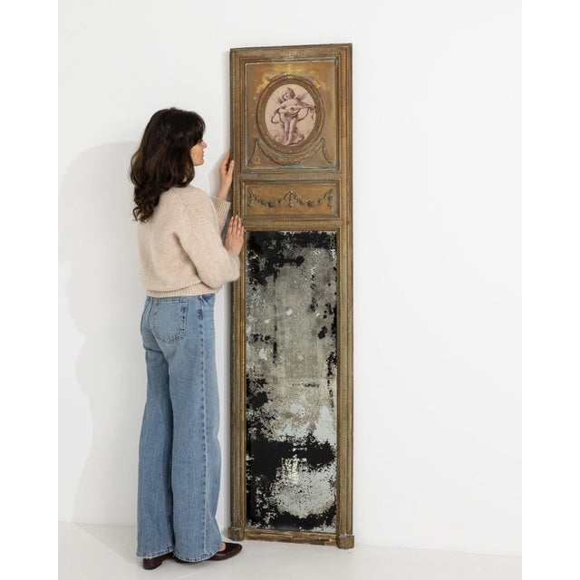 This mirror carries genuine presence, its distressed gold gilt, floral swag motif immediately setting the tone for the...