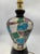 Handcrafted table lamp with a glossy black glazed ceramic base, featuring a classic vase shape with a sinuous profile and...