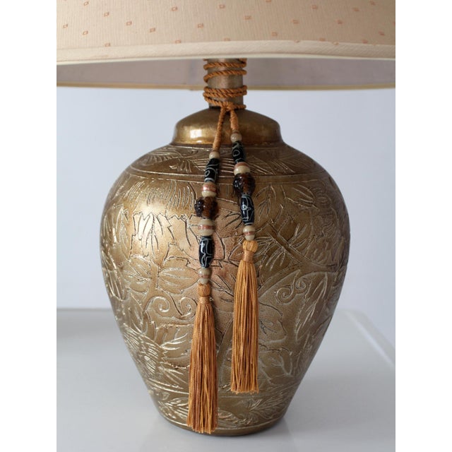 A handsome pair of vintage Chinoiserie-style table lamps featuring gilt ceramic vase-form bodies adorned with delicate...
