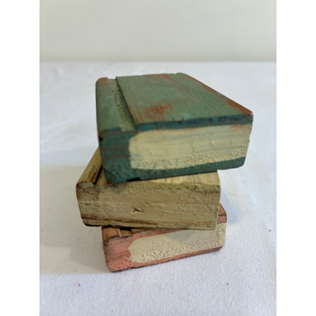 A vintage finds decorative accent full of storybook charm — this small stack of hand-painted wooden faux books features...
