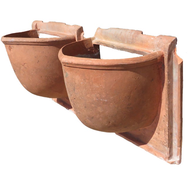 A pair of large unglazed terracotta architectural elements sourced through a to-the-trade importer of European antiques....