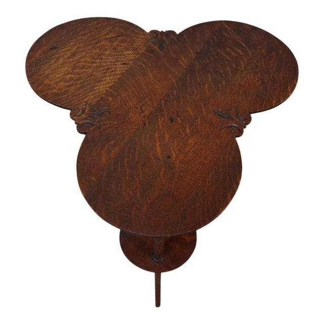 An antique Horner inspired oak side table, circa 1910, featuring a distinctive cloverleaf design. This unsigned piece...