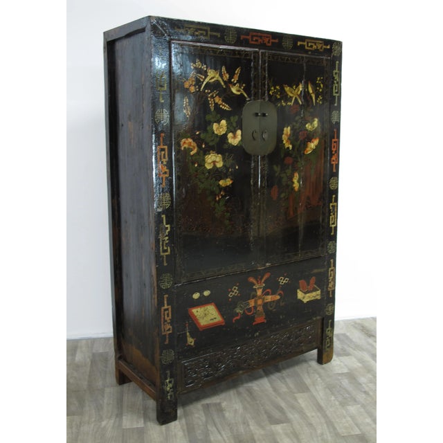 The two panels door of this black Chinese Chinoiserie cabinet is adorn with hand painted flowers and flying butterfly and...