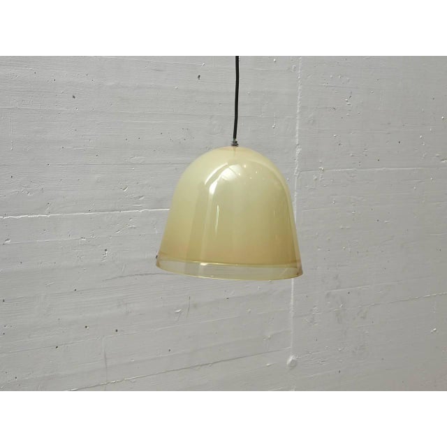 A distinctive pendant lamp in the italian space age design style, featuring a hemispherical shade made of translucent...