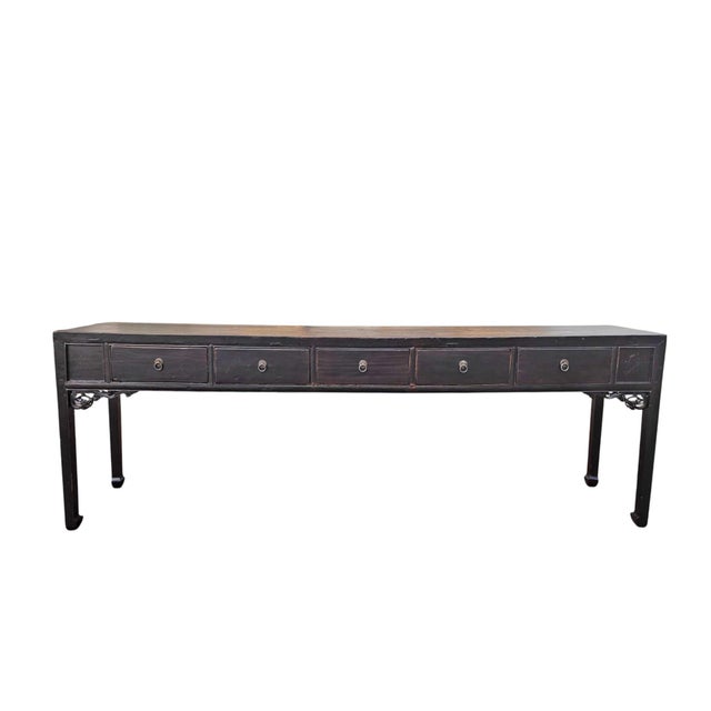This 19th century console table features an exceptionally long, narrow silhouette finished in a rich, dark lacquer that...