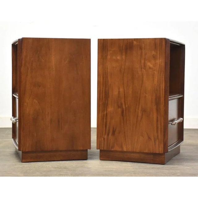 A pair of mid century modern walnut spear tip nightstands designed by T.H. Robsjohn Gibbings for Widdicomb with aluminum...
