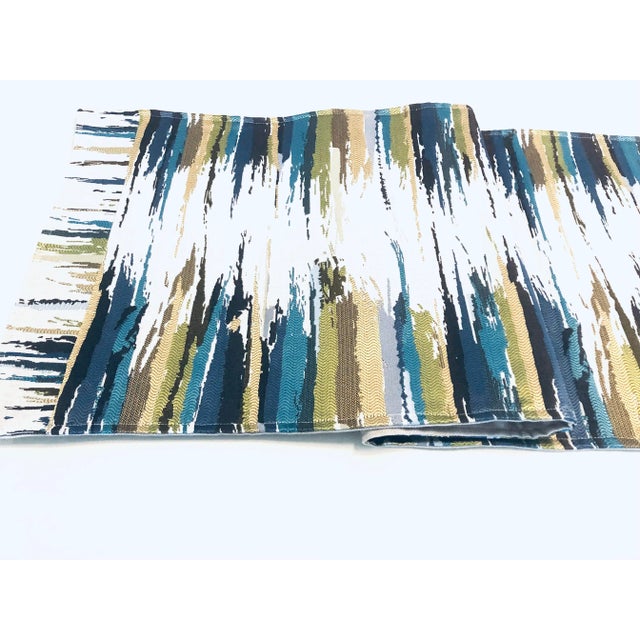 Stunning handmade table runner made with designer woven fabric in teal, green and blue colors on neutral background....
