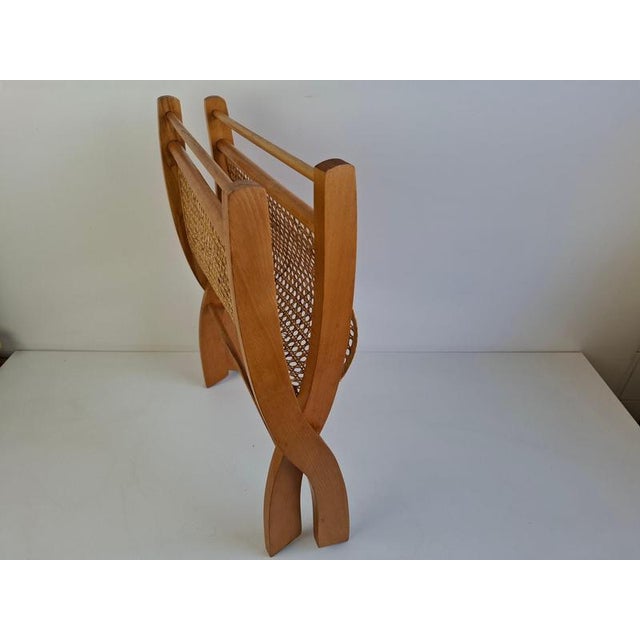 A distinctive vintage folding magazine rack from czechoslovakia, circa 1960, combining a warm wooden frame with a woven...