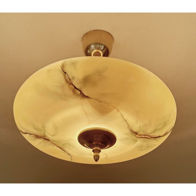 Art Deco pendant lamp with an amber glass shade with darker green and butterscotch veins and patches, brass canopy, finial...