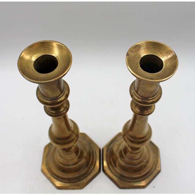 Pair of brass candlesticks, circa 1860, English. Turned inverse vasi-form middle flanked by pinched sections over...
