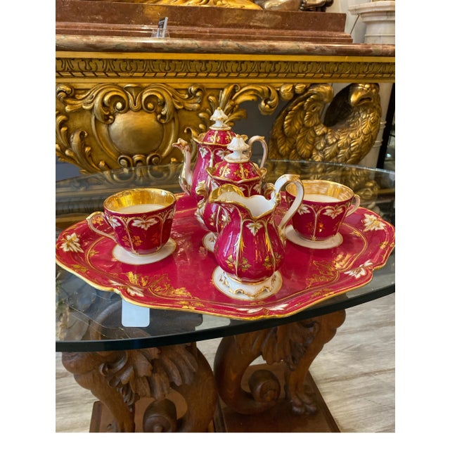 Elegant 19th century porcelain in white gold and crimson raspberry. The teapot with lid, sugar bowl with lid, creamer, two...