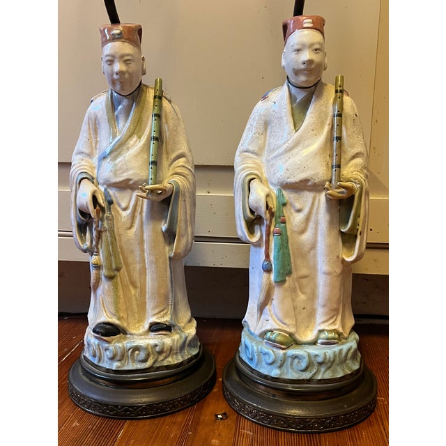 Pair antique early 20th century Chinese pottery figures of musician attendants with flutes mounted as table lamps. Each...
