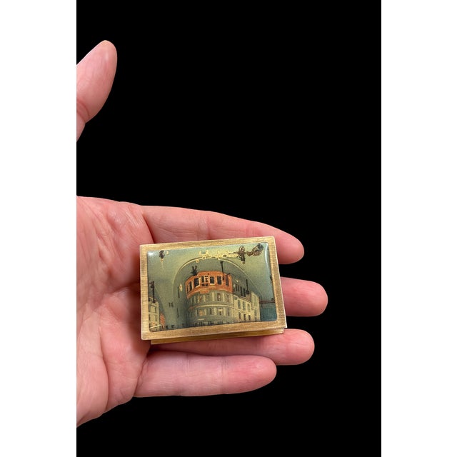 Chic little souvenir of the City of Light: a brass matchbox cover engraved “PARIS” on the side and faced with a charming...