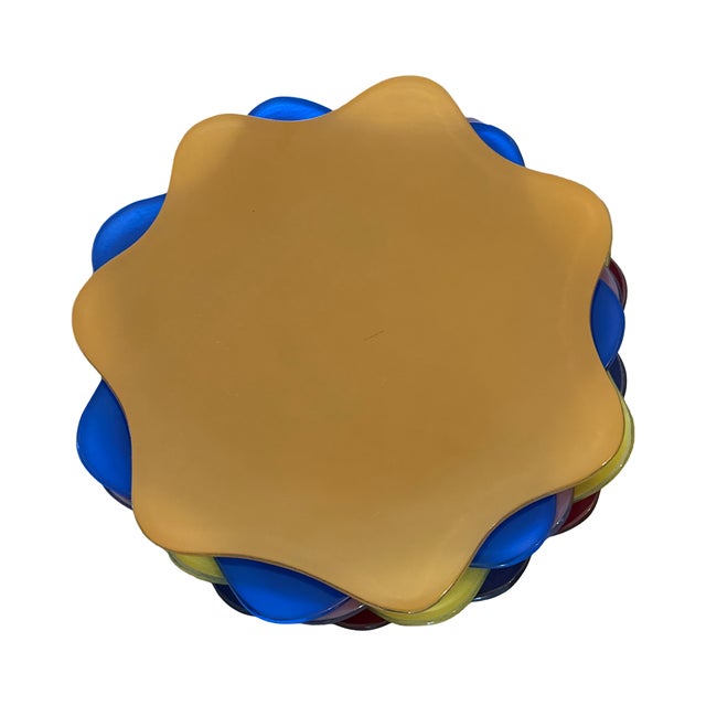 Set of nine hand-formed Annieglass chargers in a striking mix of saturated colors including cobalt, amber, moss green,...