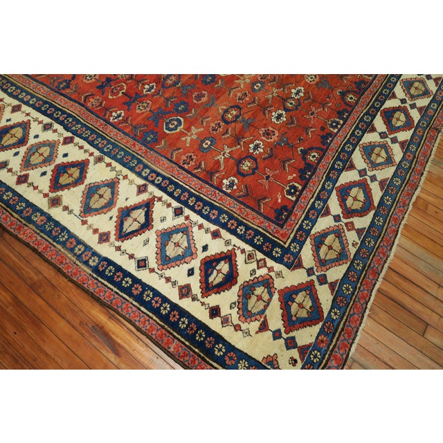 Stunning Antique Persian Bakshaish Rug with an allover pattern of polychrome shrubs on the madder field is within an ivory...