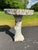 A single vintage faux bois concrete round bird bath with white painted finish.