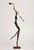 A contemporary figurative bronze of a woman playing a trumpet, her body elongated into a single tall, swaying line and...