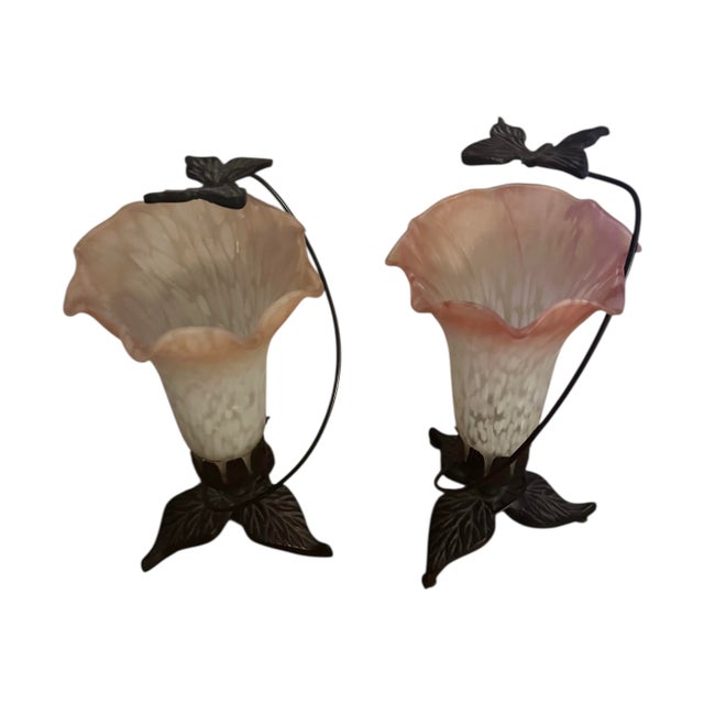 A pair of unique lily lamps that are beautiful and different. Each lamp has a cast iron base and a satin glass lily style...