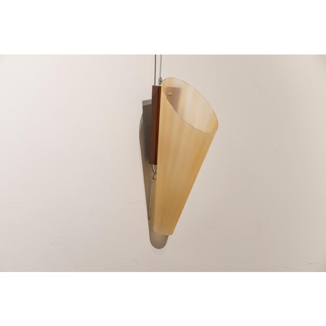 A pair of large, amber-colored, cone-shaped glass wall sconces with wooden brackets. The glass shades are opaque, wavy,...