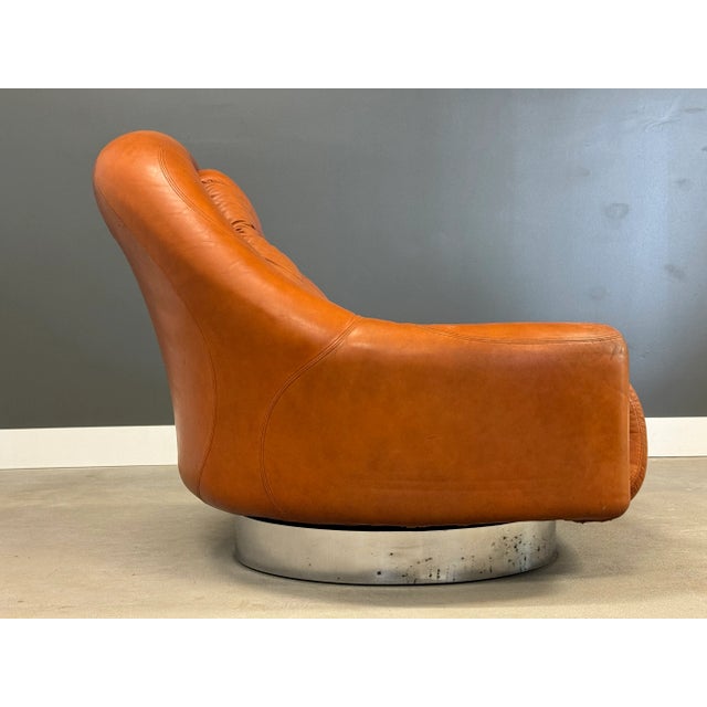 A mid century modern brown patinated leather swivel lounge chair designed by Guido Faleschini for Mariana. Made in Italy....