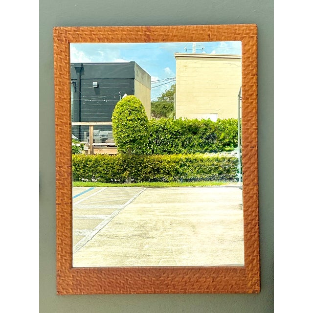 This vintage rectangular wall mirror showcases exceptional mid-century craftsmanship with its richly textured woven...