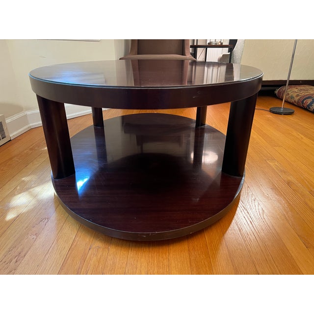 Offering an oval coffee table from the Barbara Barry Collection for Baker Furniture. Finished in a dark wood, the table...