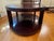 Offering an oval coffee table from the Barbara Barry Collection for Baker Furniture. Finished in a dark wood, the table...