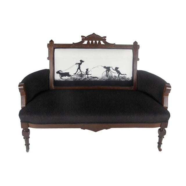 This Eastlake settee features fabric created from an antique black and white German silhouette. The impish scene depicts...