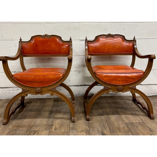 This is a gorgeous and rare pair of vintage Victorian style carved walnut Savonarola parlor arm chairs with orange or...
