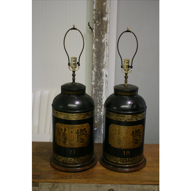 Vintage chinoiserie style black and gold tole lamps. Each lamp is marked: "Rudduck & Compy. Complete shop fitters for all...