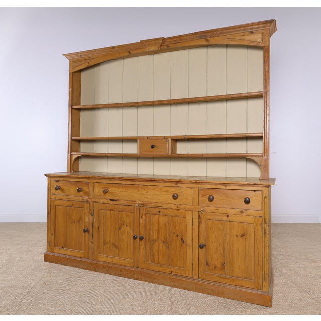 A beautiful oversized antique English pine dresser with wonderful warmth, character, and an impressive 87-inch width....