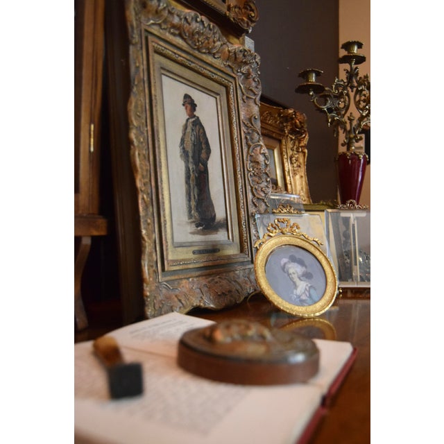 An exquisite 19th-century bronze and wood paperweight featuring a detailed relief portrait of a Renaissance nobleman in...