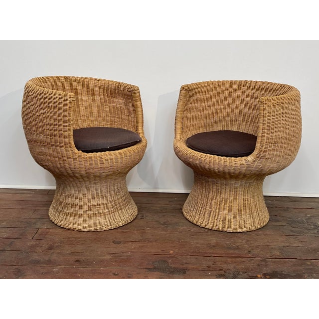 A fine pair of woven wicker "tulip" shaped lounge chairs in the manner of Eero Aarnio. One retains its original tag,...
