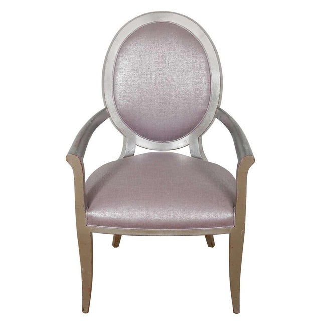 A graceful pair of French painted armchairs in the Louis XVI style, featuring classic oval medallion backs and gently...