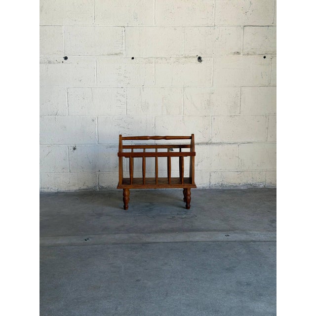 Designed with turned spindle rails and a central carrying handle, this compact piece brings warmth and function to any...