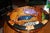 A vibrant and whimsical decorative wooden bowl featuring an eye-catching collection of colorful fish swimming across a...