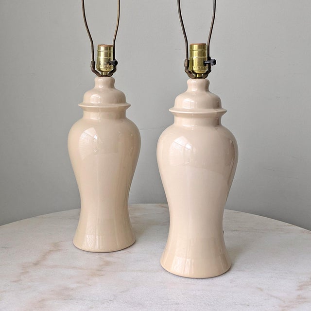 A pair of vintage Hollywood Regency style ginger jar lamps with original lampshade harps and finials. Measurements: 5.5 ʺL...